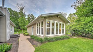 A small, single-story house with a covered porch, a concrete pathway leading to the entrance, and a well-maintained lawn.