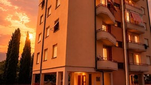 Un edificio a più piani con balconi, tetto piatto e un lampione.