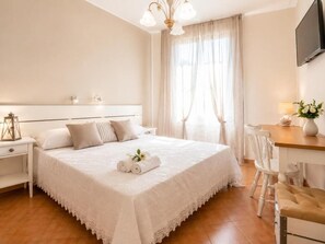 Une chambre d’hôtel avec un grand lit, un bureau et une chaise.