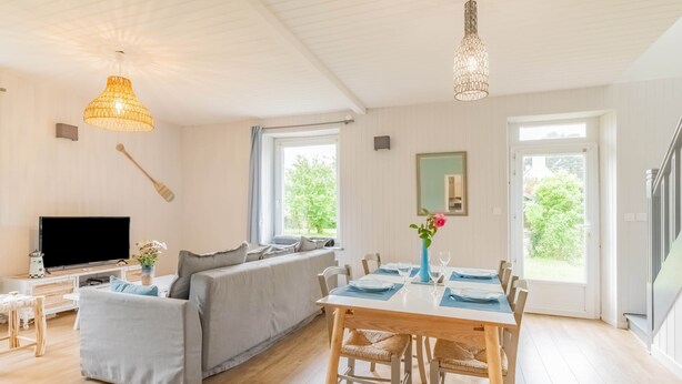 Una sala de estar moderna con un sofá, una mesa de comedor y un televisor.