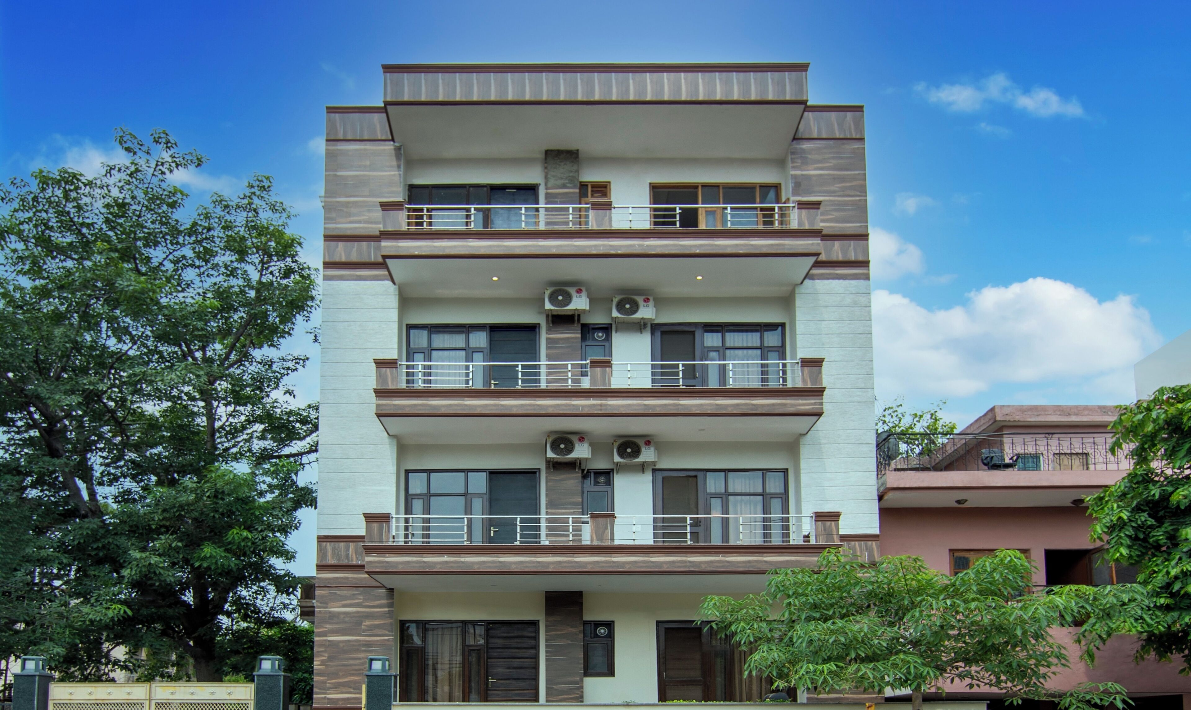 A multi-story residential building with balconies, air conditioning units, and a gated entrance.