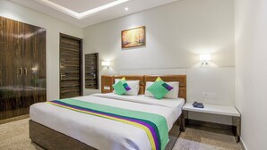 Una habitación de hotel con una cama grande, un armario, un cuadro en la pared y lámparas de noche.