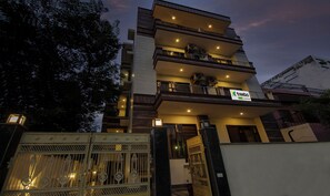 A multi-story building with balconies and a gated entrance. - Treebo Swastika Premium (Noida)