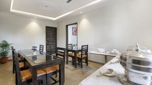 Un comedor moderno con una mesa de vidrio, sillas de madera y un espacio para buffet.