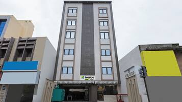 A multi-story hotel with a central vertical feature, a sign for 'treebo trend OSCAR', and a 'HOTEL OSCAR' sign on the right.