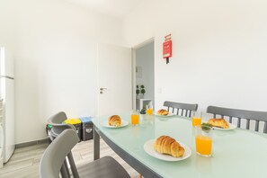 A dining area with a table set for breakfast, including croissants and orange juice. - Casa da Avó by Atlantic Holiday (Caniçal)