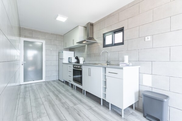 A modern kitchen with white cabinetry, a stainless steel oven, and a built-in microwave.