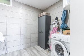 A laundry area with a washing machine, a dryer, and a drying rack. - Casa da Avó 2 by Atlantic Holiday (Caniçal)