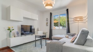 A modern living room with a flat-screen TV, a sofa, a coffee table, and a window with curtains. - Yellow Rose by Atlantic Holiday (Funchal)