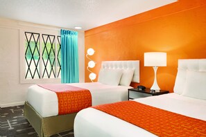 A hotel room with two beds, a window with a view, and a nightstand with a lamp.