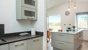 Una cocina moderna con una isla grande, armarios empotrados y vistas al exterior.