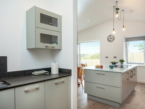 Una cocina moderna con una isla grande, armarios empotrados y vistas al exterior.