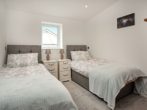 A bedroom with two beds, a window, a nightstand with lamps, and a wall-mounted picture. - 2 bedroom accommodation in Langford Hele, near Marhamchurch (Langford Hele, near Marhamchurch)