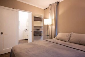 Comfortable room with a bed, bedside table, and wardrobe.