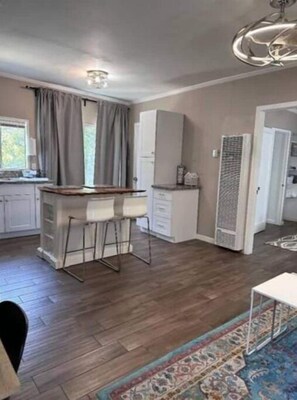 Enjoy meals in the spacious kitchen and dining area, featuring a central island with bar stools and a large window.