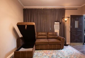 Relax in this stylish room with a comfortable leather sofa and matching chair, complemented by a patterned rug and elegant door design.