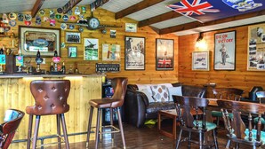 Un espace bar avec des murs en bois, un drapeau et divers objets de collection.