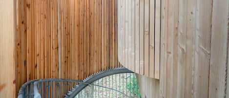 Un interior de madera con una escalera espiral y lámparas colgantes.