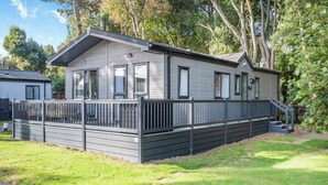 Une maison mobile de plain-pied, dotée d’un porche couvert et d’une cour clôturée.