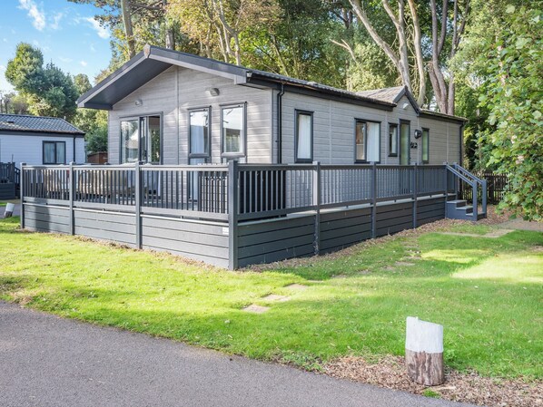 A single-story mobile home with a covered porch and a fenced yard. - 2 bedroom accommodation in Lowestoft (Lowestoft)