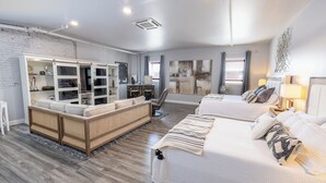 Une chambre moderne avec un grand lit, un canapé et une armoire intégrée.