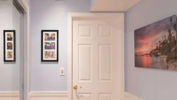 A hallway with wooden flooring, a white door, and a table with a white tablecloth.