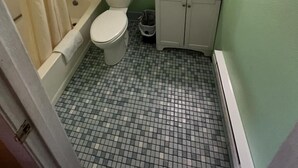 Un baño con inodoro, lavamanos y ducha.