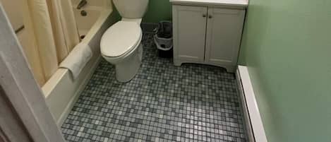 Une salle de bain avec des toilettes, un lavabo et une douche.