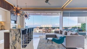 Un salon moderne avec un îlot en marbre, un canapé et un coin repas avec des chaises.