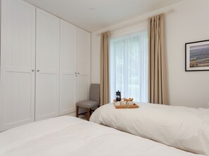 A bedroom with two beds, a chair, a bedside table with a tray, and a large wardrobe. - 3 bedroom accommodation in Beauworth, near Alresford (Beauworth, near Alresford)