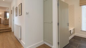 A hallway with a radiator, a door, and a staircase leading to another room. - 3 bedroom accommodation in Beauworth, near Alresford (Beauworth, near Alresford)
