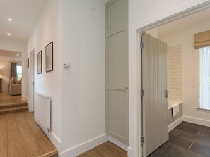 A hallway with a radiator, a door, and a staircase leading to another room. - 3 bedroom accommodation in Beauworth, near Alresford (Beauworth, near Alresford)