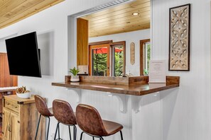 Un'area reception con un bancone in legno, un televisore a schermo piatto, un cartello di benvenuto e un elemento decorativo incorniciato.
