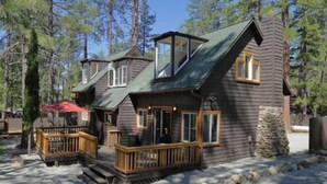 Eine Holzhütte mit Veranda und Steinverkleidung.