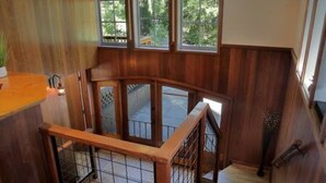 Eine Holztreppe mit Glasgeländer, die zu einer oberen Etage führt.