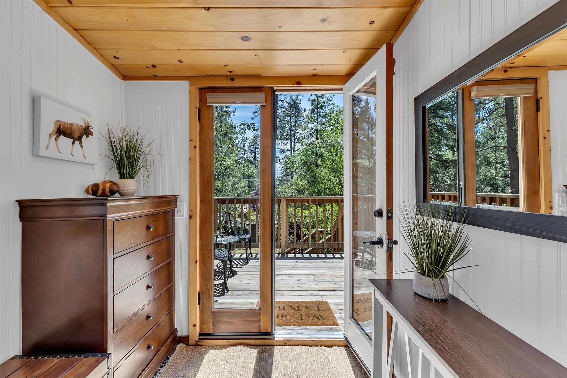 A wooden interior with a sliding glass door leading to an outdoor deck.