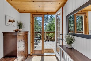 A wooden interior with a sliding glass door leading to an outdoor deck. - La Petite - cozy fireplace cabin in town (Idyllwild-Pine Cove)