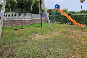 A playground with swings and a slide.