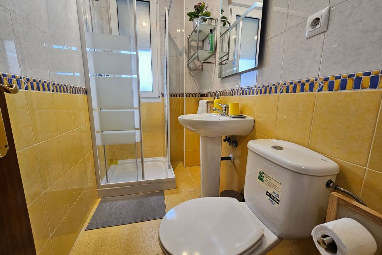 Ein Badezimmer mit Toilette, Waschbecken und einer Duschkabine aus Glas.