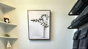 A bathroom with a toilet, a framed artwork above the toilet, and a towel rack with towels. - Center City with Recent Renos
(King & Double Beds) (St. John's)