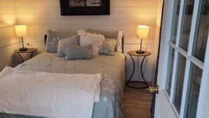Una camera da letto con un letto, due comodini e una porta.