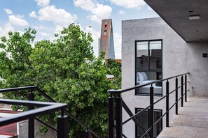 A modern building with a concrete exterior, a glass door, and a metal railing. - Santa Maria Apartments by VH (Mexico City)
