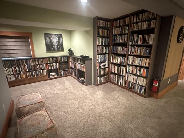A library with bookshelves, a fireplace, and a framed picture on the wall. - Coveted creekside setting, near downtown and Bogert Park. (Bozeman)