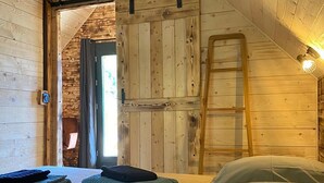 A cozy attic bedroom with wooden walls, a loft bed, and a ladder. - Bogs des Bauges Chalet L'arcalod (Arith)