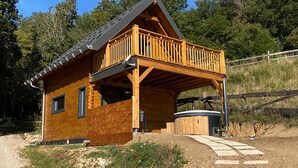 A wooden cabin with a balcony, a porch, and a stone pathway leading to the entrance. - Bogs des Bauges Chalet L'arcalod (Arith)