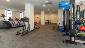 Et fitnesscenter med løbebånd, træningsmaskiner og forskelligt træningsudstyr.