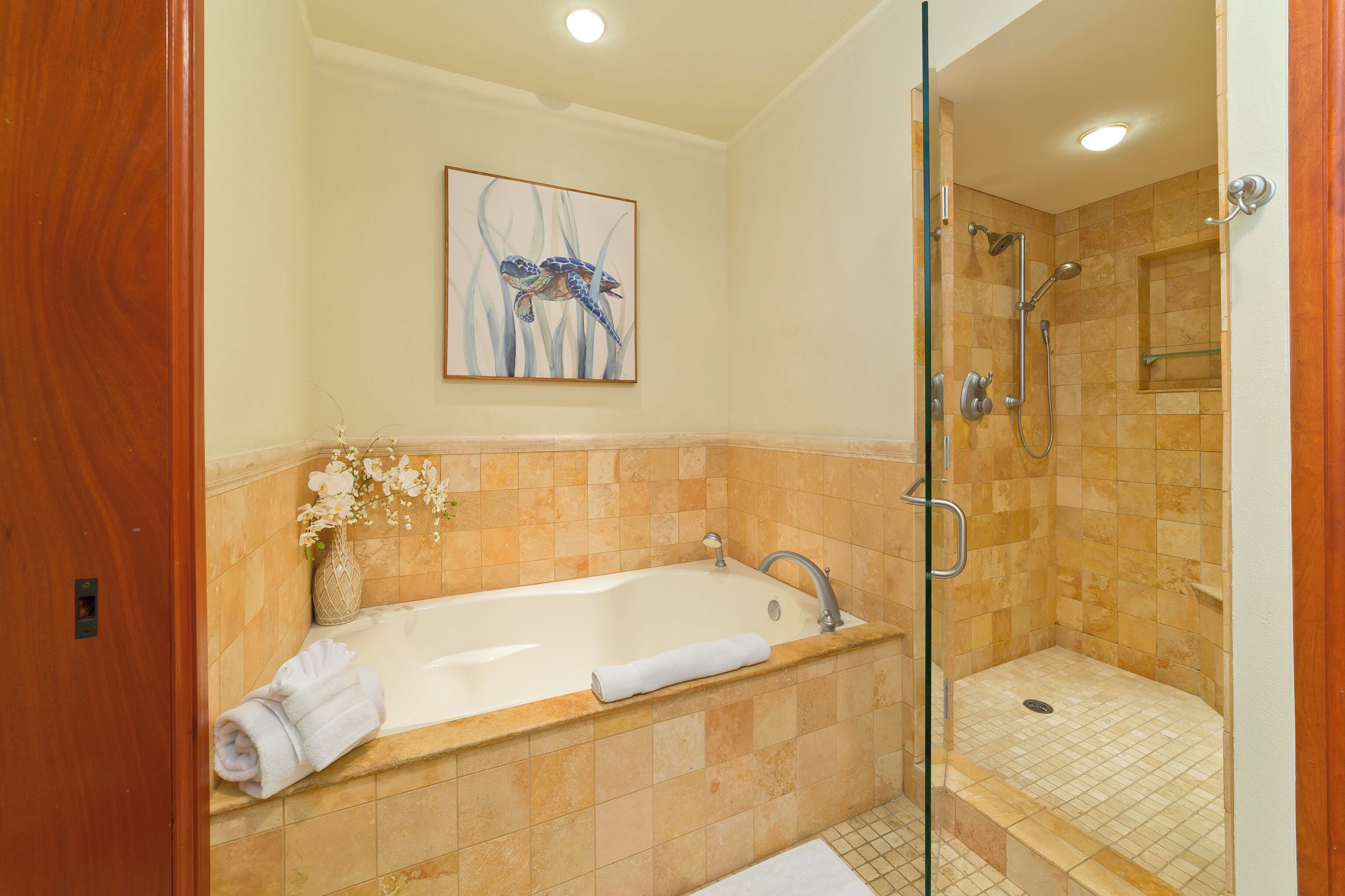 A bathroom with a bathtub, a shower, and a glass-enclosed shower area.
