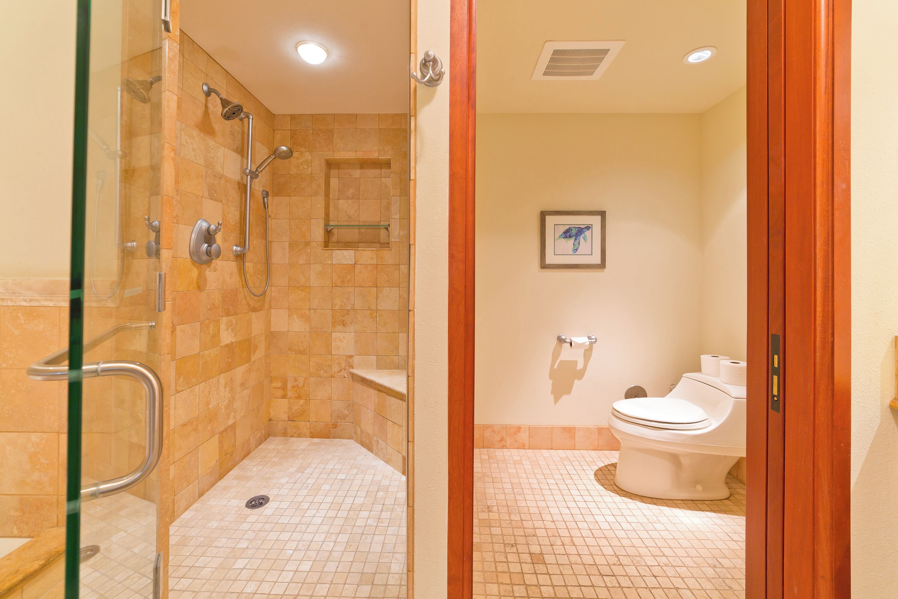Une salle de bain avec une douche à parois de verre, des toilettes et un lavabo.