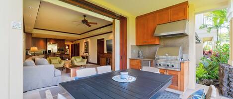 An open-plan living and dining area with a kitchen, a dining table, and a sofa.
