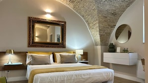 A bedroom with a large bed, a nightstand, a lamp, a dresser, and a mirror. - B&B La Fabbrica di San Pietro (Vasto)